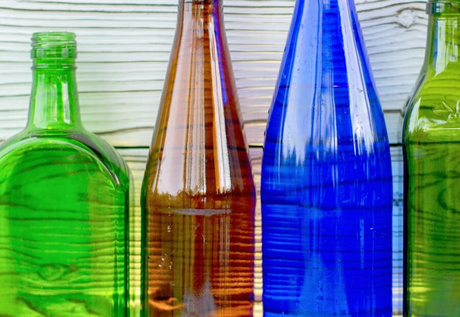 Bottiglie di vetro colorate su un tavolo di legno